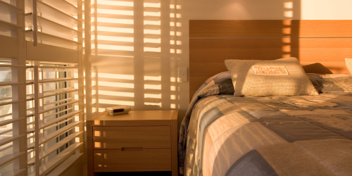 a bed with a lot of light coming through the windows