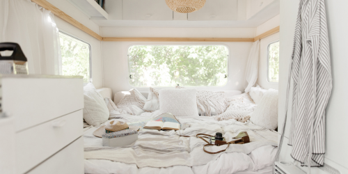 white bedroom with white curtains and pillows